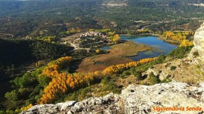 Ruta Circular del Escalerón a la Raya en Uña: Todo lo que Debes Saber. 20 Vista panorámica de la laguna de Uña y el pueblo desde un mirador, con el bosque en colores otoñales.