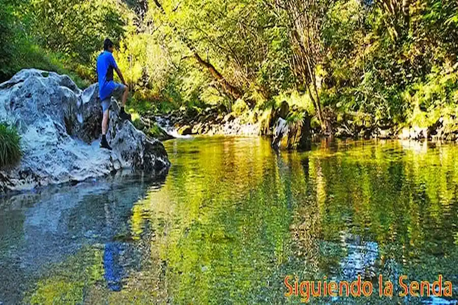 Senderistas disfrutando de una de las pozas del río Casaño, ideal para un baño refrescante en verano.